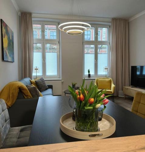 a living room with a vase of flowers on a table at Stadt-Idyll Schwerin im Zentrum in Schwerin