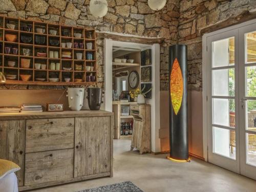 ein Wohnzimmer mit einer Steinmauer und einem Fenster in der Unterkunft la Casa dei Gatti a Seccheto, una chicca in Seccheto