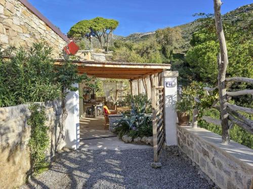 eine hölzerne Pergola mit einem Tisch und einigen Pflanzen in der Unterkunft la Casa dei Gatti a Seccheto, una chicca in Seccheto