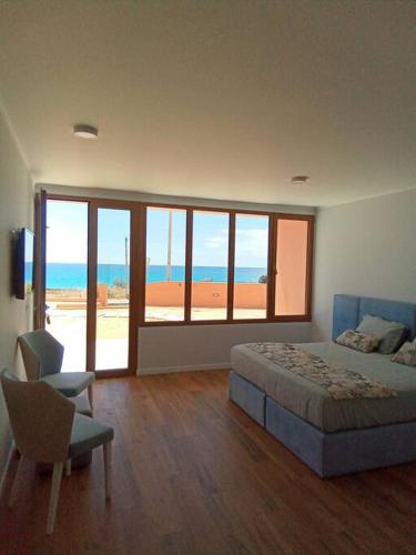 een slaapkamer met een bed en uitzicht op de oceaan bij Praia Encantada in Porto Santo