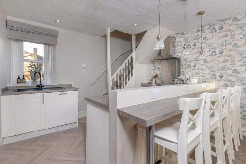 a kitchen with white cabinets and a sink and a counter at Brunswick Cottage in Penrith