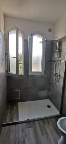 une salle de bain avec douche et toilettes et une fenêtre dans l'établissement Appartement entre mer et montagne avec beau jardin, à Calenzana