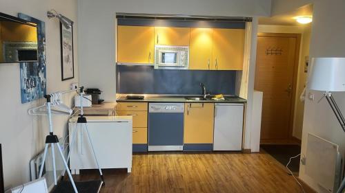 坎丹奇奧的住宿－Apartamento Riglos2 Candanchu，厨房配有黄色橱柜和水槽