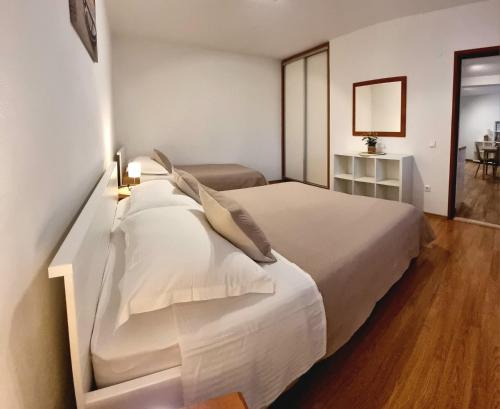 a bedroom with a large white bed with a mirror at Accommodation Huljić in Hvar