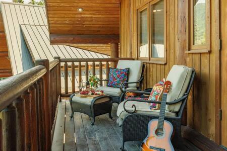 a porch with two chairs and a guitar on a cabin at Luxury Family Cabin at Summit West in Snoqualmie Pass