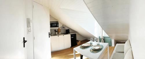 Il comprend un salon avec une table blanche et une cuisine. dans l'établissement HIDDEN NOOK NANTES - Studio plein centre Nantes, à Nantes