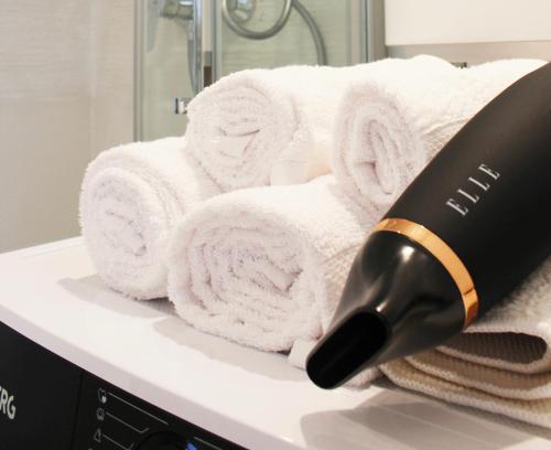 un sèche-cheveux posé sur un comptoir de salle de bain avec des serviettes dans l'établissement HIDDEN NOOK NANTES - Studio plein centre Nantes, à Nantes