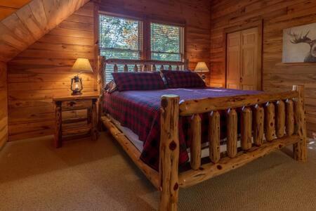 a bedroom with a bed in a log cabin at Torch Lake Cabin In The Woods THE HEART OF TORCH in Bellaire