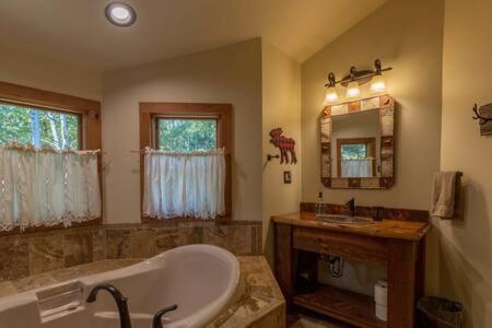 a large bathroom with a tub and a sink at Torch Lake Cabin In The Woods THE HEART OF TORCH in Bellaire
