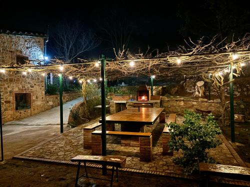 a patio with a table and lights at night at Masía Can Janet in Arbúcies