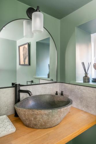a large stone sink in a bathroom with green walls at Gibson Cottage, Penrith, The Lake District in Penrith
