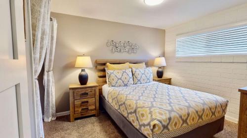 a bedroom with a bed and two lamps and a window at Downtown Cozy Home Base - Purple Sage 4 in Moab