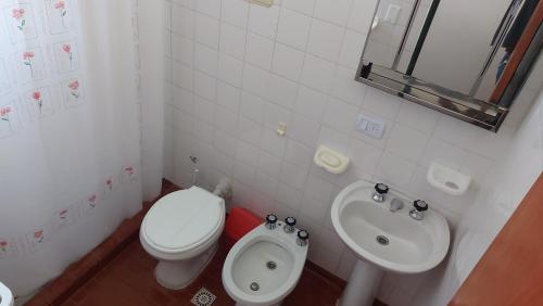 Baño blanco con aseo y lavamanos en Castillo Del Lago - Carlos Paz - D16 en Villa Carlos Paz