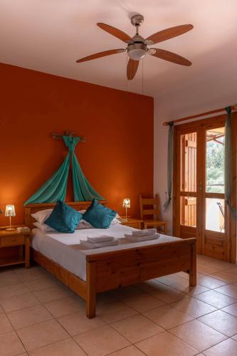 a bedroom with a bed with a ceiling fan at Villa Helios, private gated pool + big patio in Almyrida