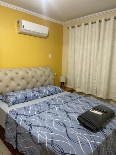 a bedroom with a bed with a pillow and a fan at Confortável e aconchegante! in Aracaju