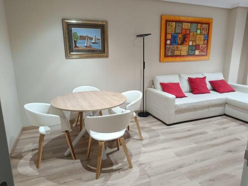 - un salon avec une table et un canapé dans l'établissement Apartamento Argandona-Gijon, à Gijón