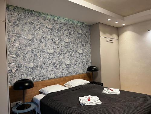 a bedroom with a bed with two towels on it at Apartman Donner Centar II in Subotica