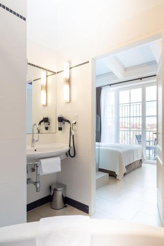 a bathroom with a sink and a bed at Hotel Spiess & Spiess in Vienna