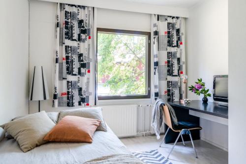 een slaapkamer met een bed, een bureau en een raam bij Air Hotel Nummela in Nummela