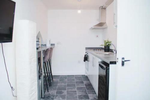 a white kitchen with a sink and a counter at Trendy 2BR Apt near Anfield Stadium in Liverpool