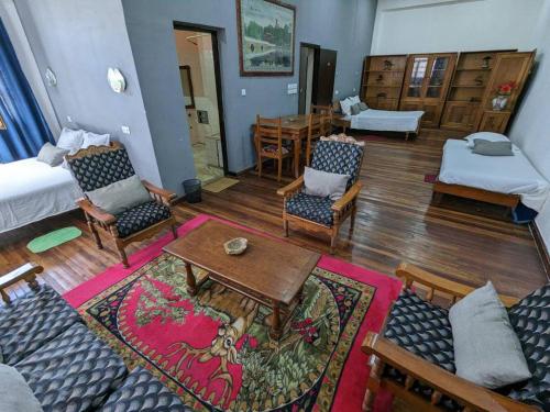 a living room with a couch and a table and chairs at Hôtel Diamant Antsirabe in Antsirabe