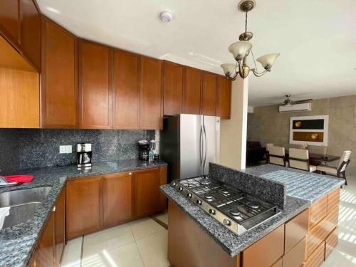 a kitchen with wooden cabinets and a stove top oven at Casa Familiar Diamante in Heroica Alvarado