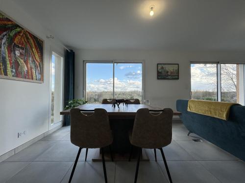 a dining room with a table and some windows at Le Bellevue 6 pers Campagne Reve au Mans in Montfort-le-Gesnois