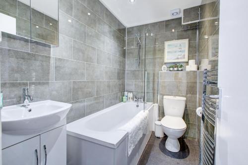 a bathroom with a sink and a toilet and a tub at Gorgeous 1 Bedroom Property in London