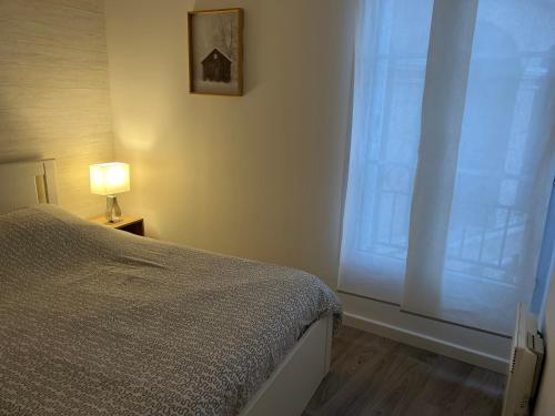 a bedroom with a bed and a large window at Le Quarante Deux in Serris