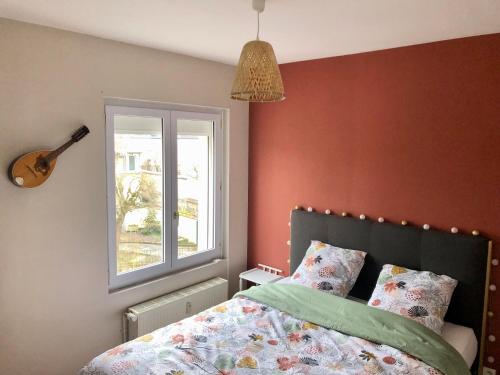 - une chambre avec un lit, une fenêtre et une guitare dans l'établissement Logement centre ville d'Epernay avec parking privé, à Épernay