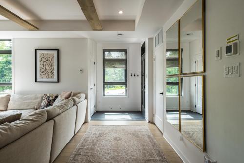 a living room with a couch and a mirror at La totale : luxury 3 BR at the mountain in Mont-Tremblant