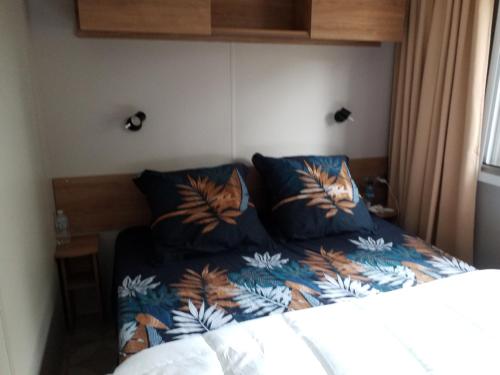 - une chambre avec un lit et une couette bleue dans l'établissement Mobil home Aventura 6-8 personnes tout confort, à Saint-Brévin-les-Pins