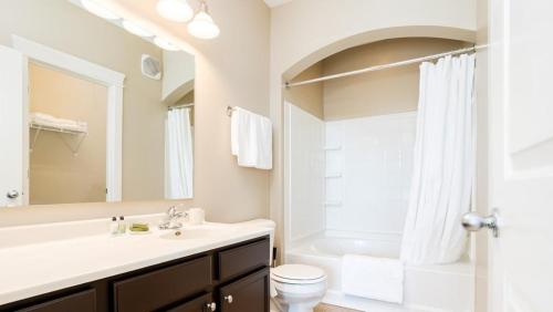 uma casa de banho com um lavatório, um WC e um espelho. em Landing - Modern Apartment with Amazing Amenities (ID8453X29) em Fishers