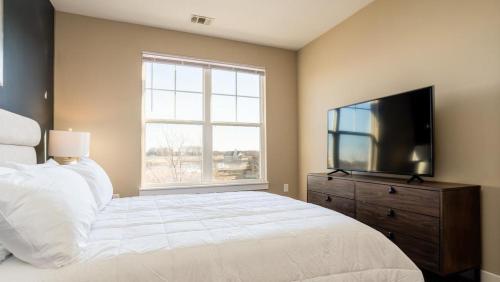 um quarto com uma cama grande e uma televisão de ecrã plano em Landing - Modern Apartment with Amazing Amenities (ID8453X29) em Fishers