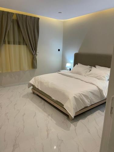 a bedroom with a large bed with marble floors at غرفة وصالة دخول ذكي العقيق in Riyadh