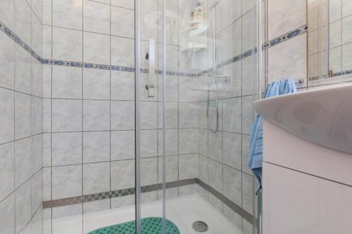a shower with a glass door next to a sink at Apartments Boris in Omiš