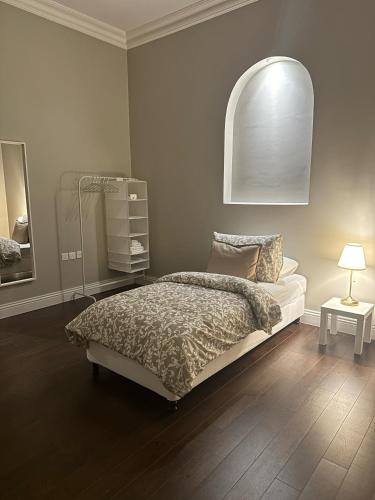 a bedroom with a bed and a lamp on a wooden floor at Apartment Fourty One in Al Khobar