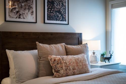 a bed with a wooden headboard and a pillow at La totale : luxury 3 BR at the mountain in Mont-Tremblant