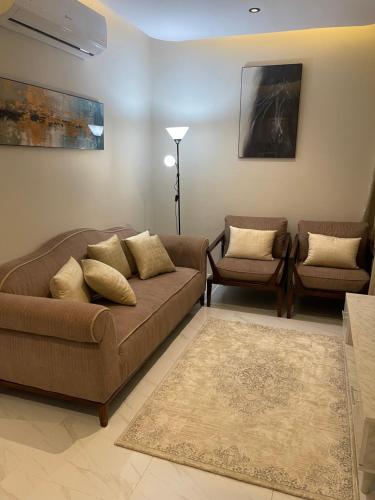 a living room with a couch and two chairs at غرفة وصالة دخول ذكي العقيق in Riyadh
