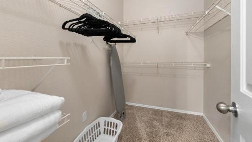 a room with a closet with a tie on the wall at Landing - Modern Apartment with Amazing Amenities (ID7762X30) in Leisure World