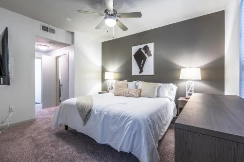 a bedroom with a white bed and a ceiling fan at Landing - Modern Apartment with Amazing Amenities (ID5045X8) in San Antonio