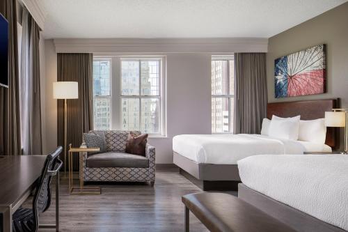 Habitación de hotel con cama y silla en Courtyard Fort Worth Downtown/Blackstone, en Fort Worth