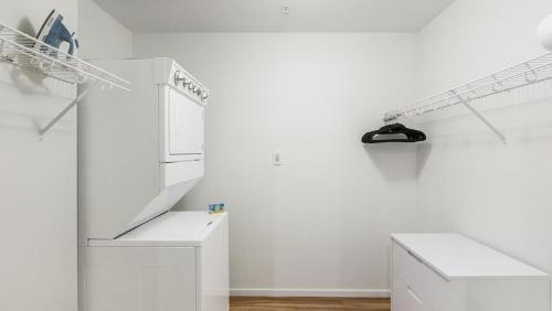 a kitchen with white walls and a white refrigerator at Landing - Modern Apartment with Amazing Amenities (ID8402X06) in Omaha