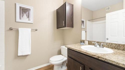 uma casa de banho com um WC branco e um lavatório. em Landing - Modern Apartment with Amazing Amenities (ID1006X02) em Chandler