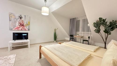 biała sypialnia z łóżkiem i telewizorem w obiekcie Moderne Appartement w Norymberdze
