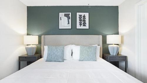 ein Schlafzimmer mit einem großen weißen Bett mit zwei Nachttischen in der Unterkunft Landing - Modern Apartment with Amazing Amenities (ID7412X03) in Orlando