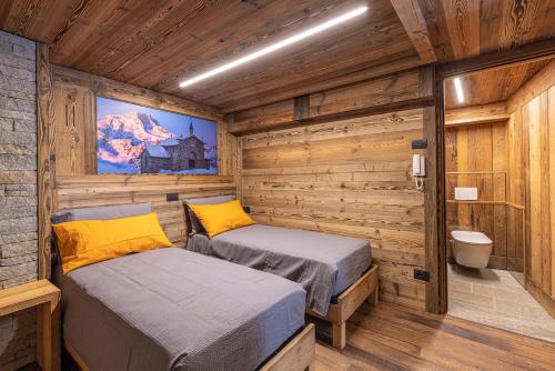 a bedroom with two beds in a log cabin at ValmalencoAlpina in Caspoggio