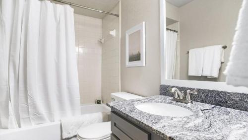 ein Bad mit einem Waschbecken, einem WC und einer Dusche in der Unterkunft Landing - Modern Apartment with Amazing Amenities (ID7412X03) in Orlando