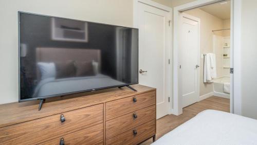 a large flat screen tv on a dresser in a bedroom at Landing - Modern Apartment with Amazing Amenities (ID2399X88) in Salt Lake City