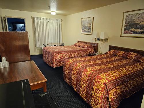a hotel room with two beds and a table at Terrace Inn and Suites in El Cerrito
